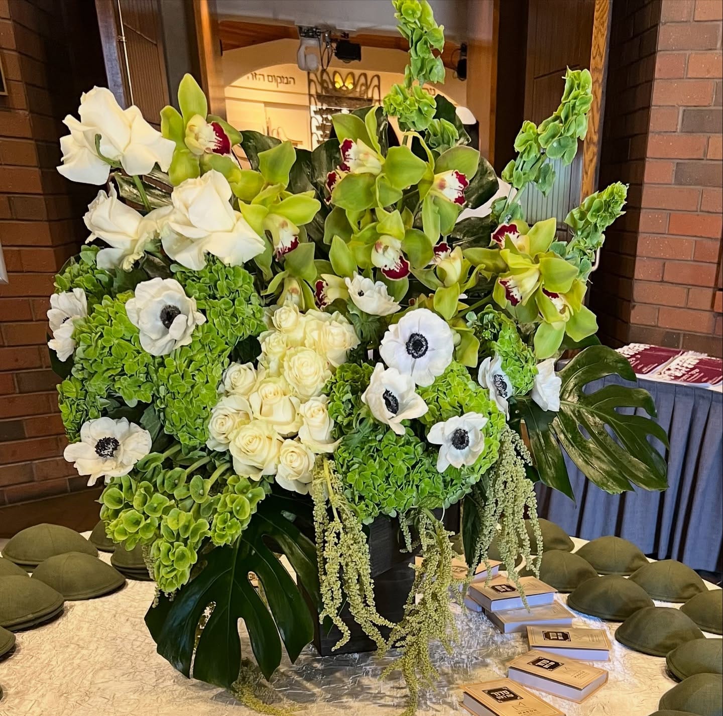Large white and green arrangement of roses, anemones, cymbidium orchids and hydrangea for a synagogue ceremony